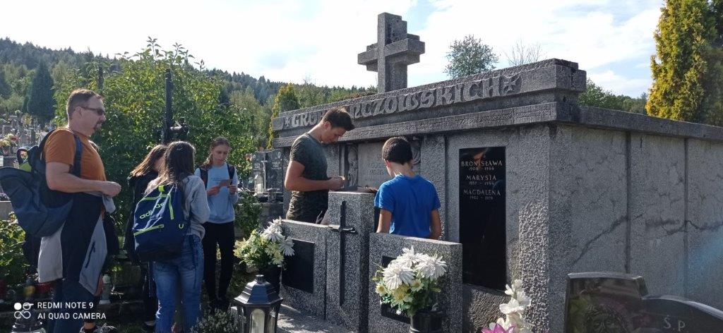 Grupa dzieci z Zakrzowa zapala znicz przy grobowcu Franciszka Lenczowskiego.