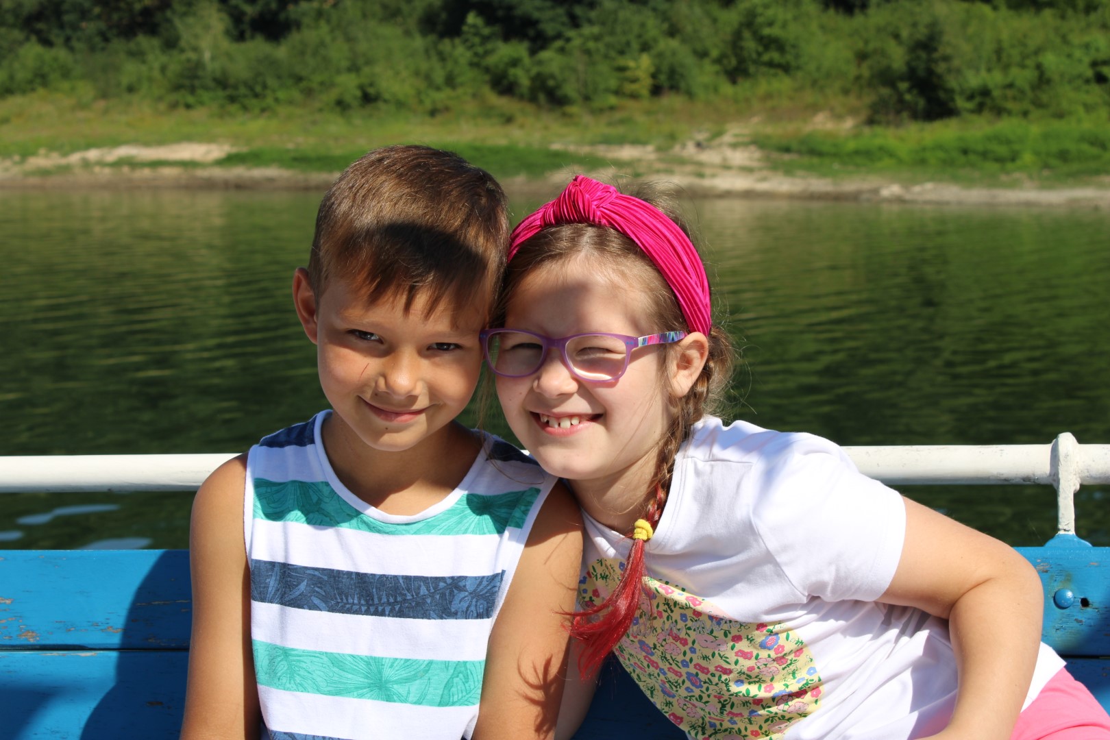 Zdjęcie przedstawia chłopca i dziewczynkę pozujących do zdjęcia na statku podczas rejsu po Jeziorze Mucharskim.