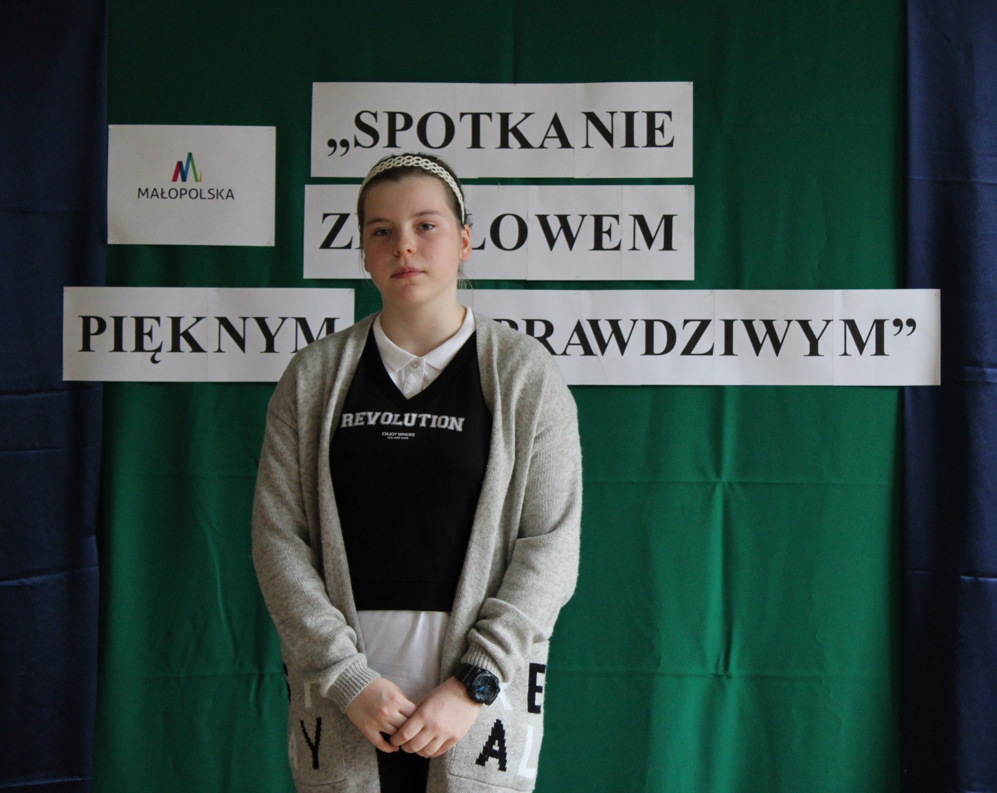 Na zdjęciu znajduje się dziewczynka, która zajęła drugie miejsce podczas Małopolskiego Konkursu Recytatorskiego – etapu gminnego „Spotkanie ze słowem pięknym i prawdziwym”, zorganizowanego na świetlicy Gminnego Ośrodka Kultury w Stroniu