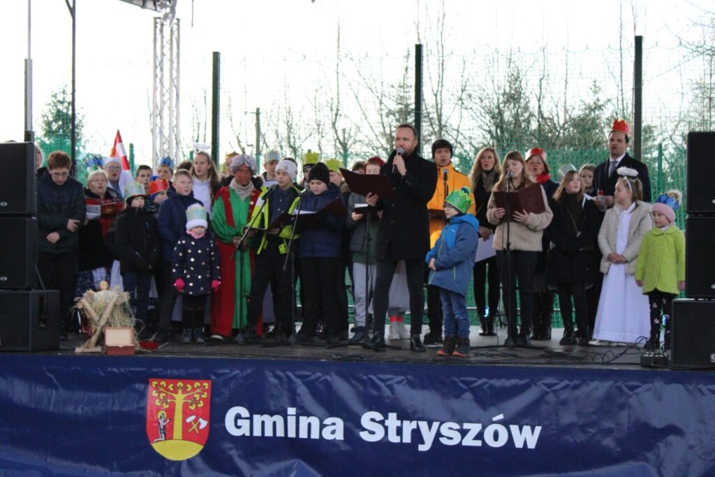 Zdjęcie przedstawia Pana Mateusza Mijala wraz z zaproszonymi na scenę uczestnikami Orszaku, podczas Koncertu Objawienie Pańskiego.