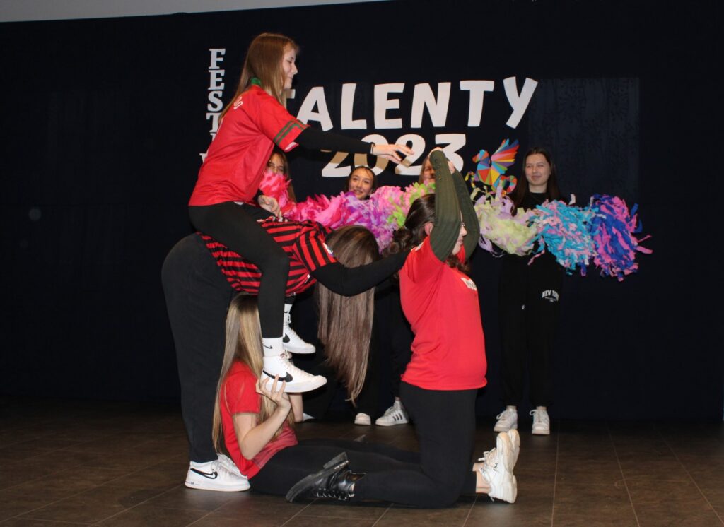 Na zdjęciu znajduje się osiem dziewczynek ze Szkoły Podstawowej im. Romana Jabłońskiego w Łękawicy, które występują na scenie podczas Międzyszkolnego Talent Show organizowanego przez Gminny Ośrodek Kultury w Stryszowie w Domu Strażaka w Łękawicy.