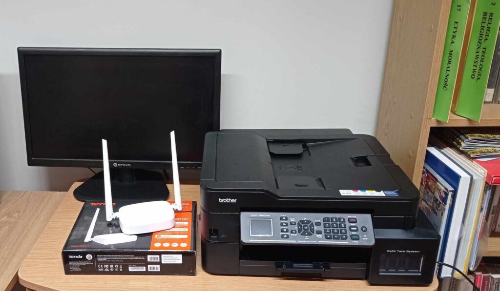 Komputer, drukarka i router na stoliku