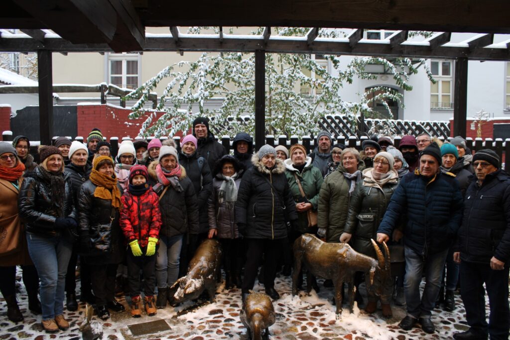grupa trzydziestu pięciu osób pozujących do zdjęcia grupowego przed figurami zwierząt we Wrocławiu.