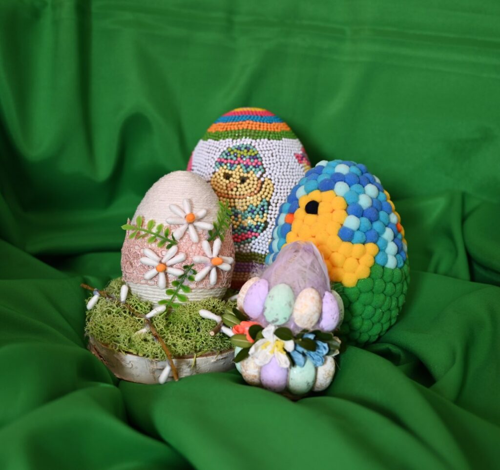 prace plastyczne z konkursu „Wielkanocna Pisanka”. Są to cztery pisanki, które są wyklejone kolorowymi koralikami, pomponami i mniejszymi jajkami.